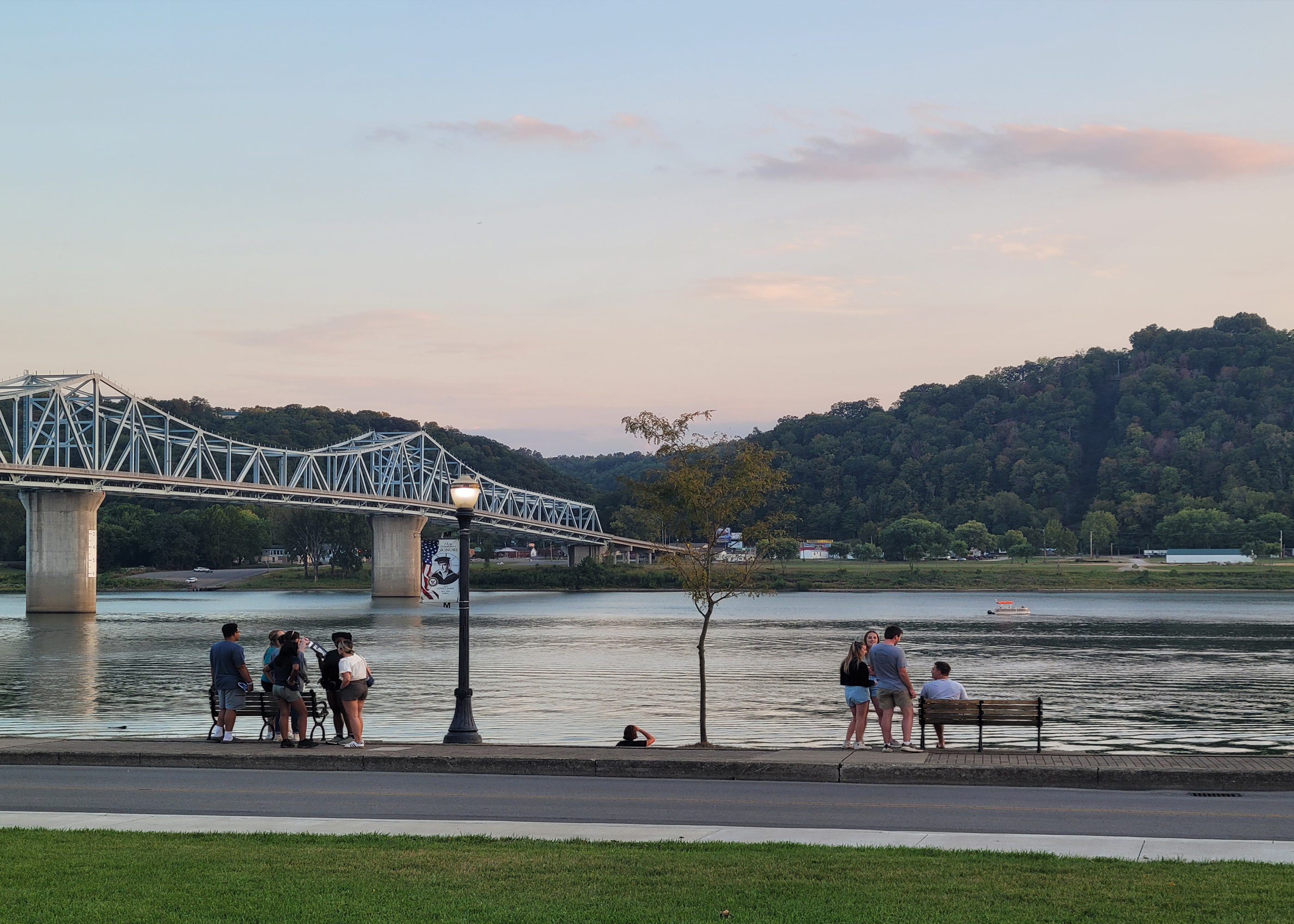 Photograph of students by the Ohio River with bridge in the background.